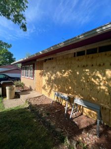 house with storm damage boarded up